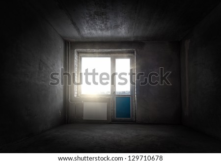Grungy empty room with gray walls and a window