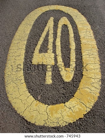 Yellow painted 40 mph speed limit on tarmac road in New Forest, Hampshire, England