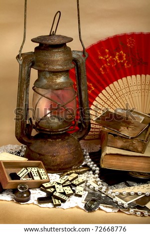 Still life - oil lamp, old photos, antique domino and jewelry