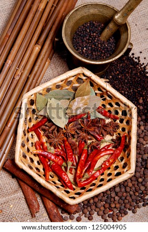 Black pepper, anise star and  bay leaf on basket with black pepper in a steel bucket. Macro