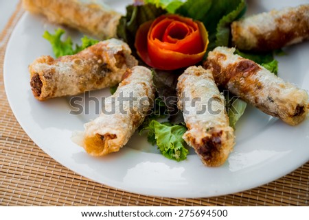 Chinese egg rolls (spring rolls) with salad on plate. Restaurant