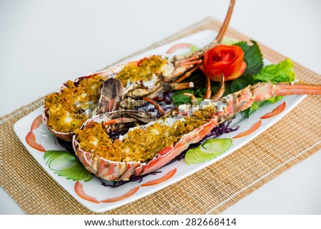 Cooked lobster with vegetables on a white plate. Restaurant.