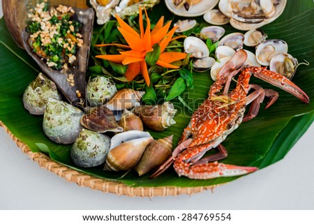 Shells and crab on the dish with the palm leaf. Restaurant