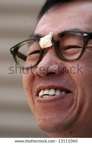 Asian man wearing broken glasses