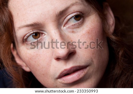 young beautiful caucasian woman without makeup brown eyes looking back
