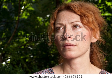 portrait of young attractive red hair woman without makeup thinking and looking upwards on morning sunshine