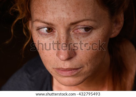 Portrait of redhead woman anxiety expression with tears in eyes trying not to cry suppressed emotion looking back