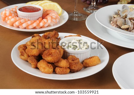 A plate of breaded calamari with shrimp and steamed clams in the half-shell