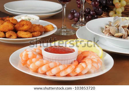 A plate of shrimp cocktail with calamari and clams