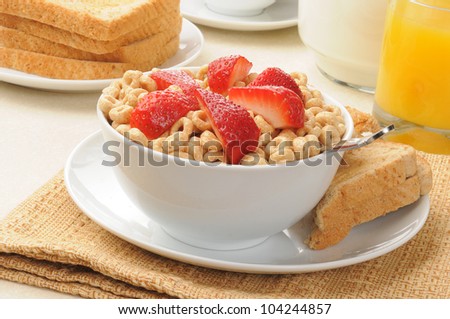 Cold breakfast cereal with fresh strawberries and buttered toast