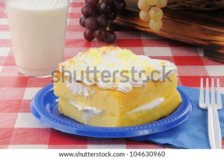 Lemon cake with cram filling and milk on a picnic table