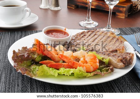 A grilled rib steak with tiger shrimp prawns