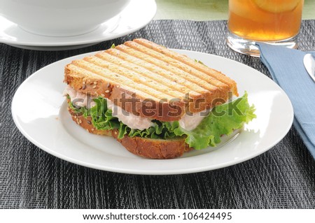 A grilled tuna sandwich with iced tea