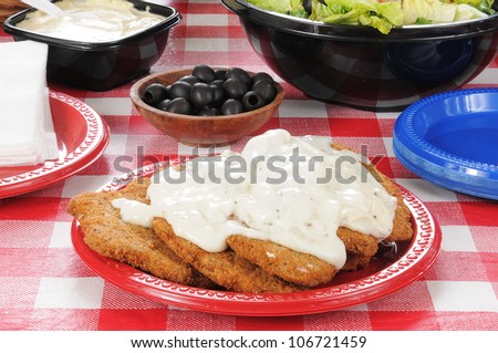 Chicken fried steak smothered in country gravy on a picnic table