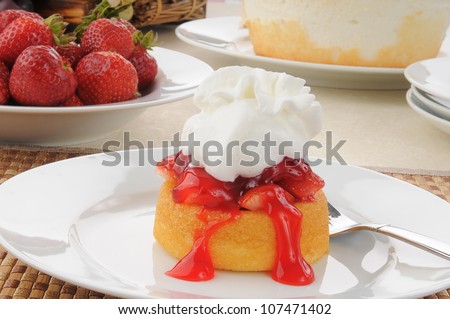 A delicious strawberry shortcake with a bowl of fresh strawberries