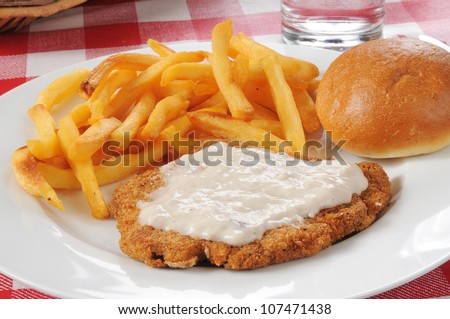 Chicken fried steak with country gravy and french fries