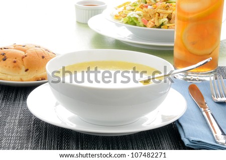 A bowl of chicken noodle soup with a taco salad