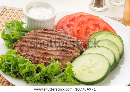 Healthy diet lunch with a grilled hamburger patty and vegetables