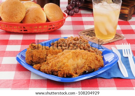A fried chicken dinner on a picnic table