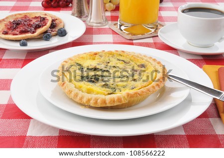 A small spinach quiche with toast and blueberry jam