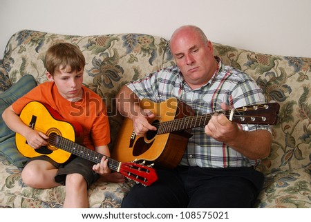 A father teaching his son how to play the guitar