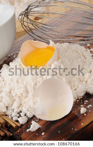 An egg yoke in the shell on a mound of baking mix