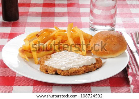 A chicken fried steak with french fries