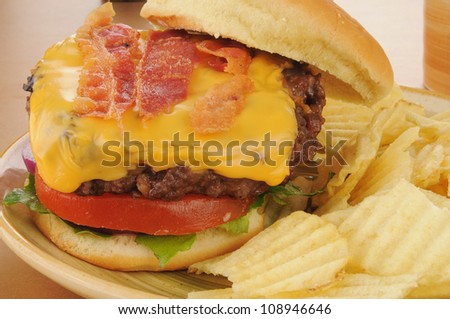 Closeup of a bacon cheeseburger with potato chips