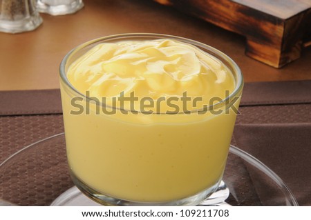 A dessert cup of vanilla pudding close up