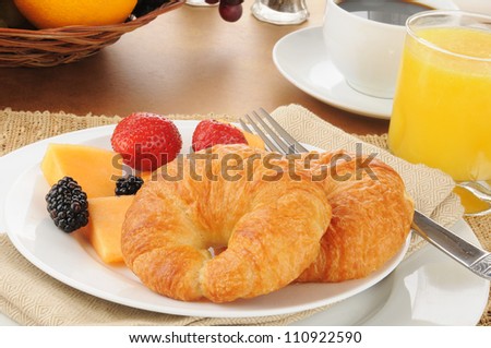 Fresh croissants with cantaloupe and berries