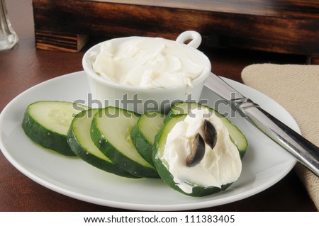 Cucumber slices with cream cheese and black olive