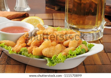 Popcorn shrimp and a mug of beer on a bar counter