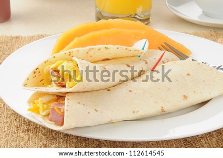 Breakfast burritos with sliced cantaloupe
