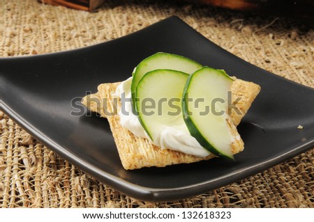 Sliced cucumber and cream cheese on shredded wheat crackers