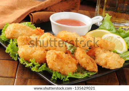A snack plate of coconut shrimp with a mug of beer