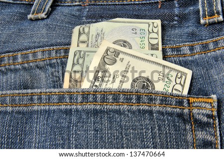Money coming out of the back pocket of a pair of blue jeans