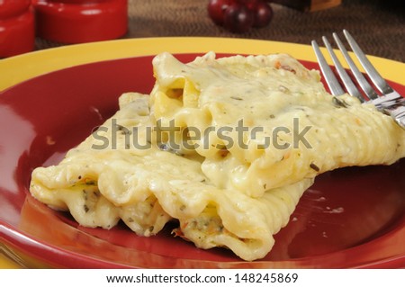 Ricotta cheese and spinach rollatini topped with Alfredo sauce and mozzarella cheese