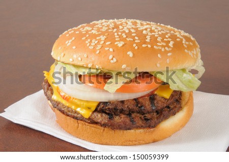 A double cheeseburger with lettuce, pickles, tomatoes and a sesame seed bun
