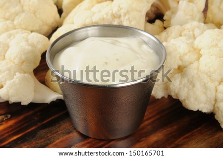 Closeup of a dish of ranch dressing with cauliflower.  Shallow depth of field, focus on front of dressing.