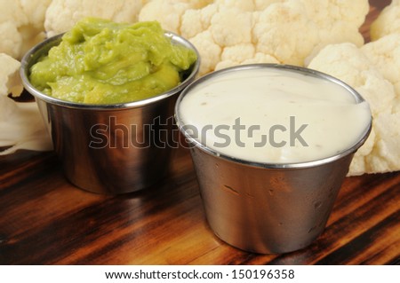 Closeup of silver dishes of ranch dip and guacamole with cauliflower