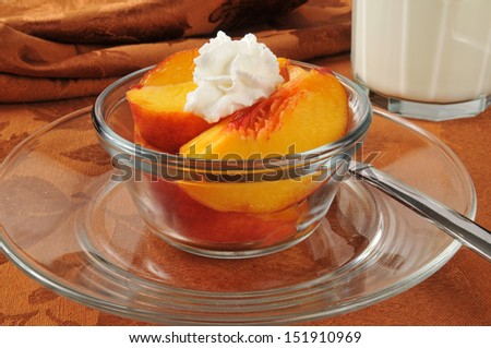 Sliced peaches with whipped cream and a glass of milk
