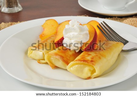 Cheese blintzes with peaches and whipped cream