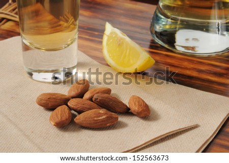 Roasted almonds on a bar napkin with a shot of tequila and beer