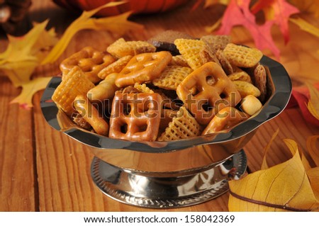 Party mix in a silver snack dish on a festive autumn setting