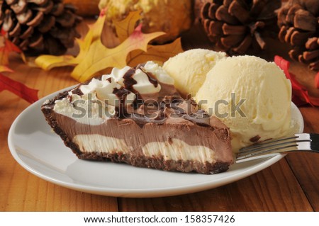 A slice of chocolate cream pie with vanilla ice cream on a colorful holiday table