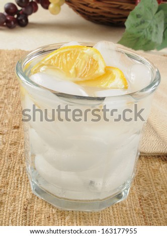 A glass of club soda with lemon wedges