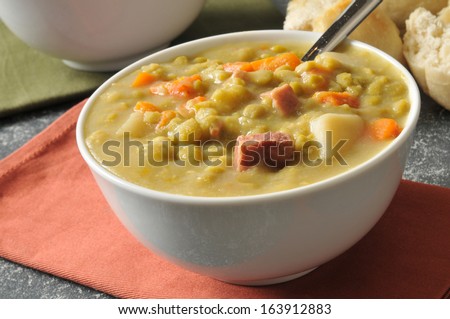 Split pea soup with chunks of ham and a dinner roll