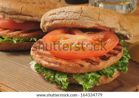 Closeup of grilled salmon burgers with a mug of beer in the background
