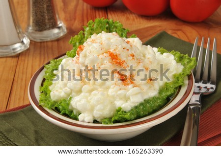 A small bowl of cottage cheese with vine tomatoes in the background