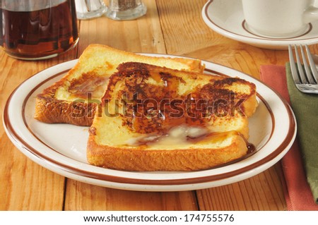 French toast with butter and syrup on a rustic wooden table